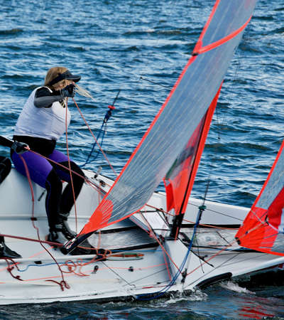 Student sailing in small colourful boat in competition. Teamwork by junior sailors racing on saltwater Lake Macquarie. Photo for commercial use.の写真素材