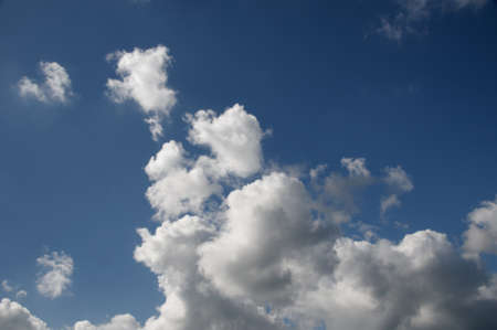 A beautiful vibrant sky cloudscape scene, with white coloured billowing cumulonimbus cloud formation in a mid blue sky. Atmospheric beauty in nature. New South Wales, Australia.の写真素材