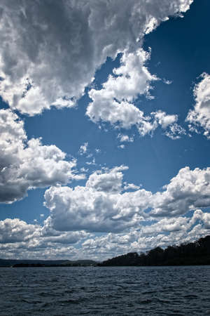 White Cumulonimbus cloud in blue sky at sea with water reflections.

East Coast, Australia.の写真素材