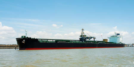A 229 meter Bulk Carrier Ship loading at a Gladstone Harbour terminal. Full length port side view. Queensland, Australiaの写真素材