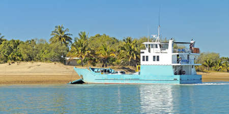Transporter Ferry delivering goods to a tropical island sandy beach. Outdoors nautical commercial use image.の写真素材