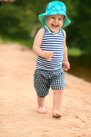 Cute baby running on the beach outdoorsの写真素材
