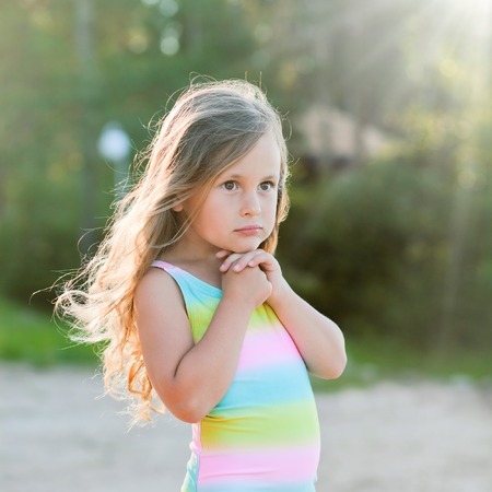 Little girl playing with sand on the beachの写真素材