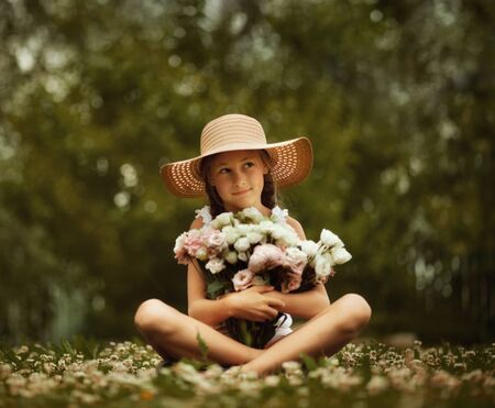 Cute young beautiful girl with two braids holding big bouquet of peonies flowers. Summertime.