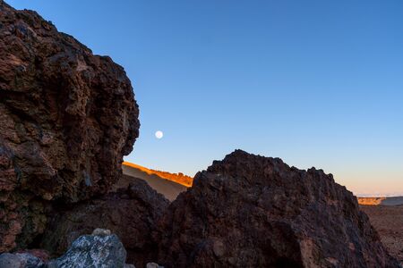 View of the rocky mountains with rising moon at sunset.の写真素材