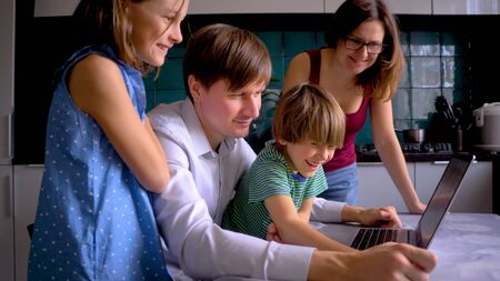 Stay home concept. Cute children use laptop for education, online study. Boy and Girl have homework at distance learning. Lifestyle concept for Family quarantine covid-19. Father helps son.の写真素材