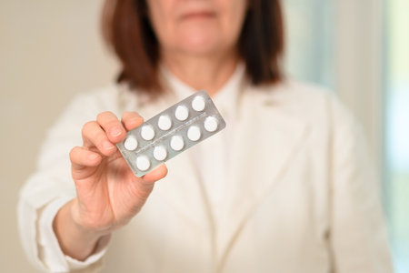 A close-up image of a female doctor extending her hand with pills. Focused on treatment and care. Represents medical support, guidance, and responsibility in prescribing health solutions.の写真素材