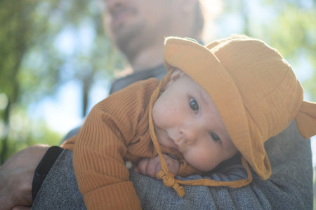 Loving dad cradling his little child in warm embrace during sunny summer day. Beautiful moment of...