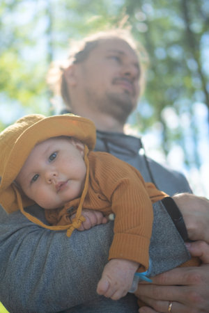 Young father holding his cheerful toddler outdoors. Heartwarming display of paternal love and family connection.の写真素材