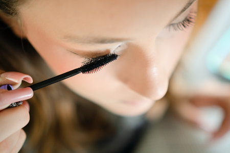 Close-up photo of a teenage girl applying mascara to enhance her eyelashes. Young, stylish girl...