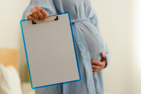 Spotless notebook in expecting mothers hands, waiting for important pregnancy notes and hospital lists. Warm home organization scene.の写真素材