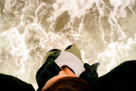 Top down photography of feet enjoying ocean waves and foam on perfect sandy beach. Summer freedom...