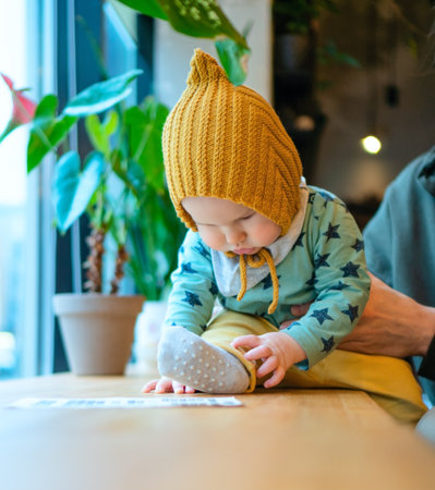 Smiling dad with toddler in cafe, showing family love and care. Modern parenthood, quality time, father and son relationship, values of family and happiness.の写真素材