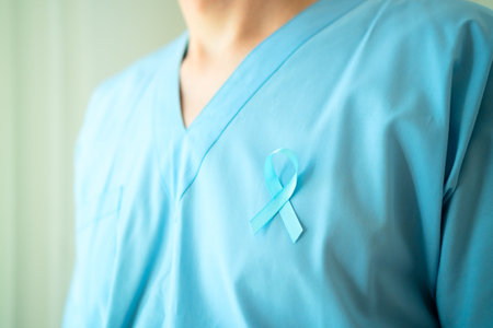 Close up of young man healthcare professional in uniform with blue satin ribbon. Symbol of prostate cancer awareness, prevention, and early medical diagnosis.の写真素材
