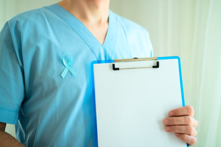 Close up of male doctor in uniform with blue satin ribbon and clipboard. Empty sheet for checklist or reminder. November prostate cancer awareness month and early medical diagnosis.の写真素材