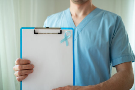 Male healthcare professional in uniform with blue ribbon symbol of prostate cancer awareness holding clipboard with empty paper for notes and reminders in November.の写真素材