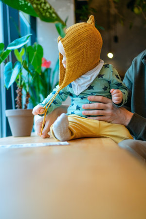 Father with child in cafe. Strong bond of parent and toddler, family values, love, happiness and modern lifestyle. Daily parenting moments of care and affection.の写真素材
