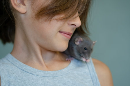 A girl holds a small pet with affection showcasing the care and love capturing the essence of their companionship and trustの写真素材