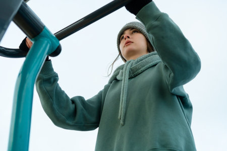 Unique view from directly underneath an outdoor fitness machine as a woman works out. the concept of...