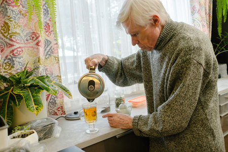 An elderly man pours tea during pleasant breakfast, focusing on enjoyment of meal. The image conveys...