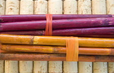 Canna-sticks (bamboo alike) bundled together with raffia on a background of cork の写真素材