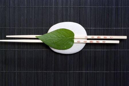 Asia still life with chopsticks and green leafの写真素材