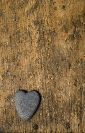 heart shaped stone on driftwood backgroundの写真素材