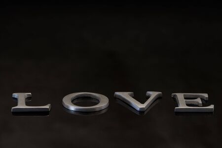 word love in metall letters on black backgroundの写真素材