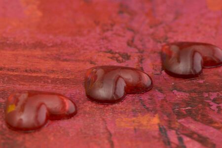 red hearts on red painted background, artwork in the back is painted by myselfの写真素材