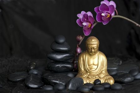 golden buddha statue with orchid flower and stone towerの写真素材