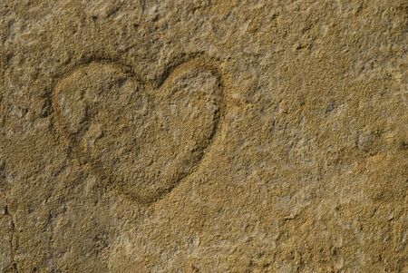 heart shape carved in sand stoneの写真素材