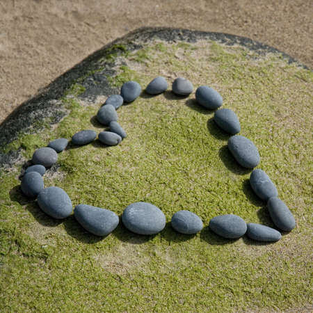 heart made of pebble on a rockの写真素材
