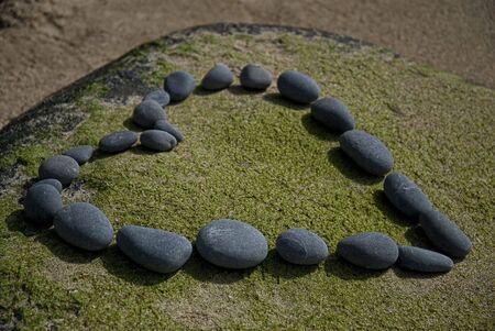 heart made of pebble on a rockの写真素材
