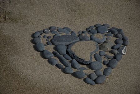 heart made of pebble on a rockの写真素材