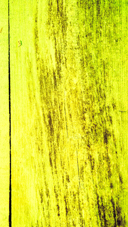 Yellow plank with cracked paint and brown dark spots. texture of old wooden planks with cracked and smeared paint. close up of vintage wooden plankの写真素材