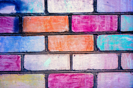 Bricks painted to rainbow color on brickwall. Colorful brick wall pattern, painted bricks as urban texture. Children painted white brick wall to different colors. Brickwall as example of children artの写真素材