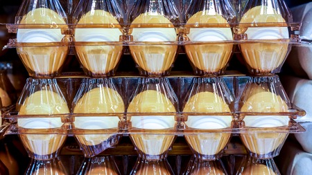 Ten white eggs in brown plastic package on market shelves. Packaging of chicken eggs on supermarket shelves cooled. Fresh eggs as perfect product for perfect breakfast omeletteの写真素材