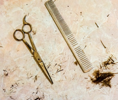 Hair cutting shears and comb against small cutting hairの写真素材