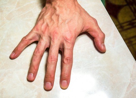 man white skin open hand on ivory table. right hand with five fingers and neat flat nails on the back of his hand up. successful businessman lay his hand on tableの写真素材