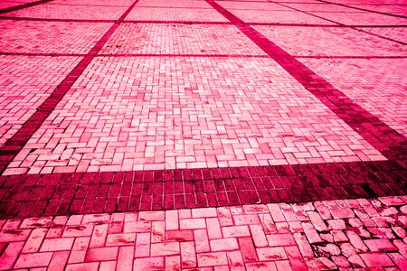 part of strong burgundy bloody diagonal layed pavement tiles with black horizontal and vertical lines, paving stone with light and dark color as textureの写真素材