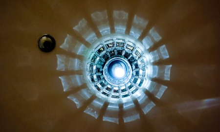 mystery circles shine around big lamp with light. Circle big chandelier with crystals, round mirror and lamps which made reflection on ceiling as star light. luxury chandelier with briliants and lightの写真素材