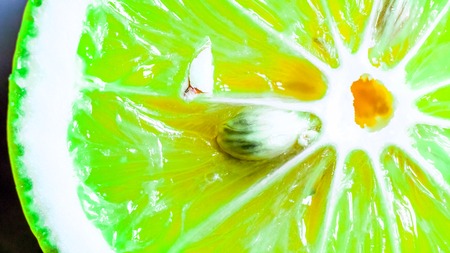 natural yellow green organic sweet juicy lime slice with white circle in the center, diagonal white...