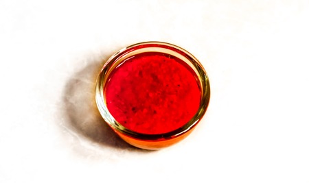 berry jam in small plate with shadow. top view to clean round glass plate with berry jam on ivory table. fresh bloody red strawberry jam . small glass plate with strawberry jam, food theme backgroundの写真素材