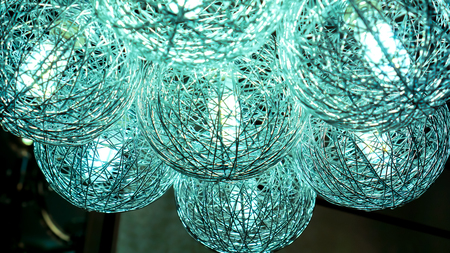 light blue lightning balls. modern art luxury chandelier made with balls with lamp inside every one, which connet to beautiful flower. Lighting ball hanging from the ceiling on backgroundの写真素材