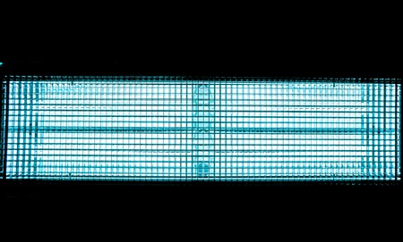 Blue metal mesh with a square pattern on a bright lamp with gradient effect on a black background as horizontal line, close-up of movie illuminant, model the motion of electrons,の写真素材