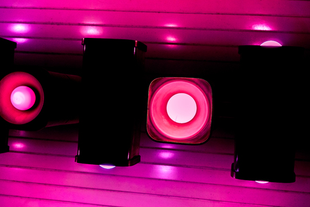 light line. crimson horizontal line lamps with Cylinder dark brass structure on ceiling with white lights against crimson dark background, modern cylinder lampsの写真素材