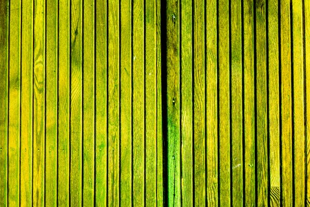 fence of green emerald vertical old wooden planks with parts of cracked paint and natural wooden texture, knots and spots. vintage wooden planks as backgroundの写真素材