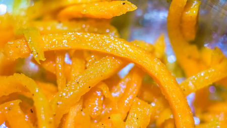 abstract circles and lines of carrot. toned to bright orange organic grated carrot with oil, paper spicies, sesame as natural texture. Fresh juicy grated carrot background close upの写真素材
