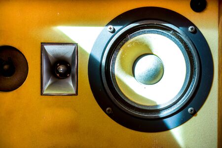 part of big old open speaker with small round Loudspeaker and black keys. Musical columns with yellow body as a source of pure sound in sunshineの写真素材