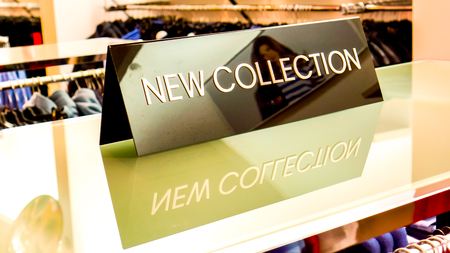 black plate in a clothing store with a sign NEW COLLECTIONの写真素材